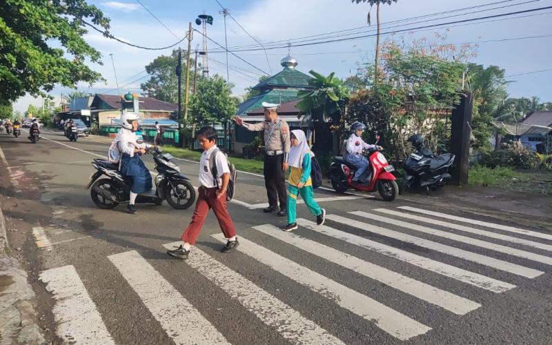 Wujud Kamseltibcar Lantas yang prima, Sat Lantas Polres BU Bantu Menyebrangkan Anak Sekolah