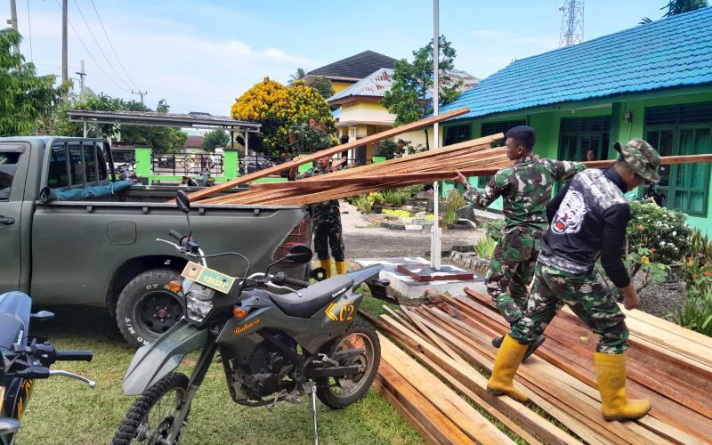 Satgas Pra TMMD ke-124 saat Bongkar Kayu Untuk Pembuatan Baliho