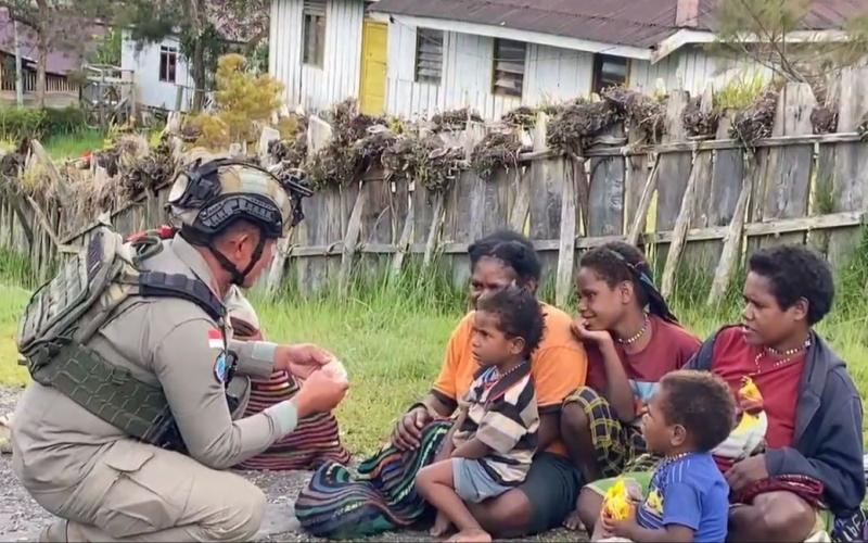 Sentuhan Humanis Satgas Damai Cartenz di Sinak Dengan Bagikan Makanan Ringan kepada Warga