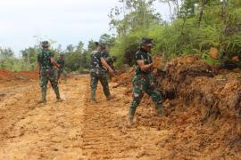 Kejar Target, Personel Satgas TMMD Lakukan Gotong Royong Ratakan Badan Jalan