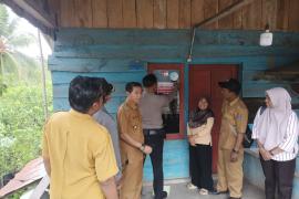 Bhabinkamtibmas Polsek Batik Nau Dampingi Tim Pendamping Desa Tempelkan Stiker di Rumah Warga