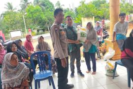Bhabinkamtibmas Polsek Ketahun Hadiri Pembagian Bantuan Pangan Beras di Desa Bukit Makmur 