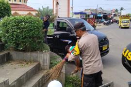Wujudkan Lingkungan Bersih, Bhabinkamtibmas Bersama Perangkat Desa Gotong Royong Bersihkan Bundaran Giri Kencana