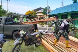 Satgas Pra TMMD ke-124 saat Bongkar Kayu Untuk Pembuatan Baliho